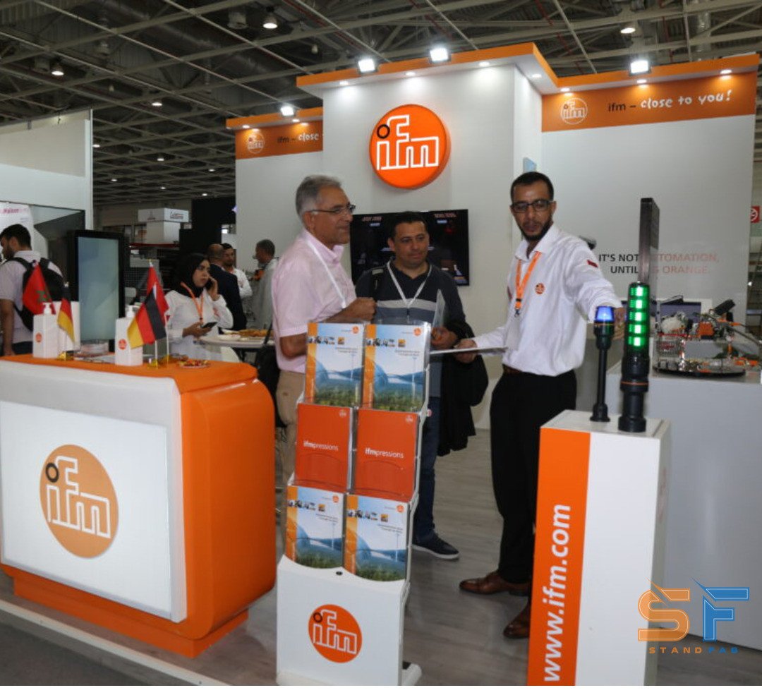Stand ifm sur salon professionnel avec comptoir d’accueil et présentoirs